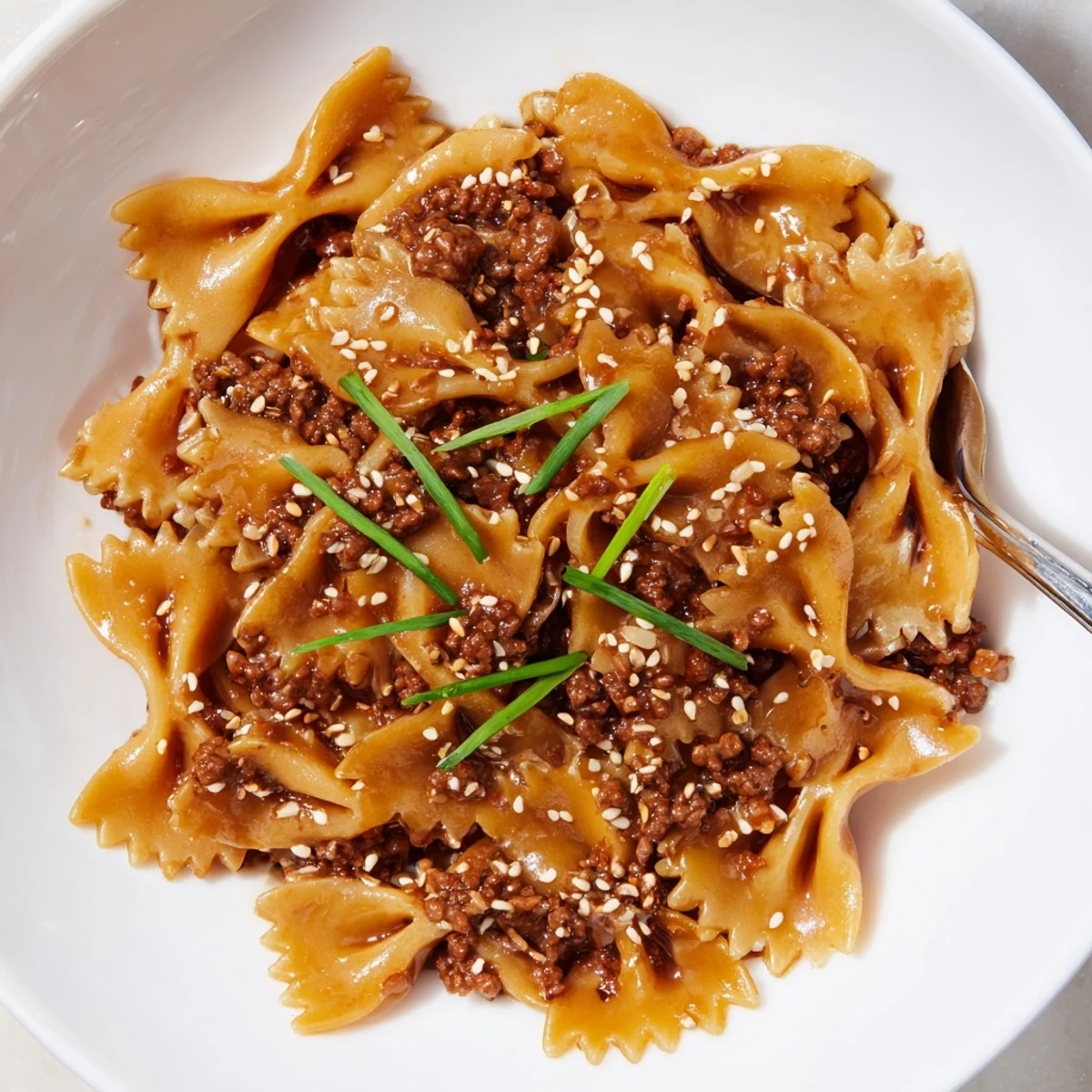 Savory Korean BBQ Beef Bowtie Pasta topped with sesame seeds and scallions.  