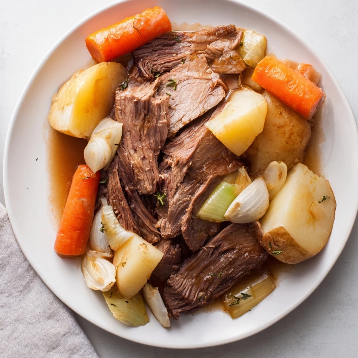 Tender Sunday Pot Roast surrounded by vibrant roasted veggies for a hearty meal.  