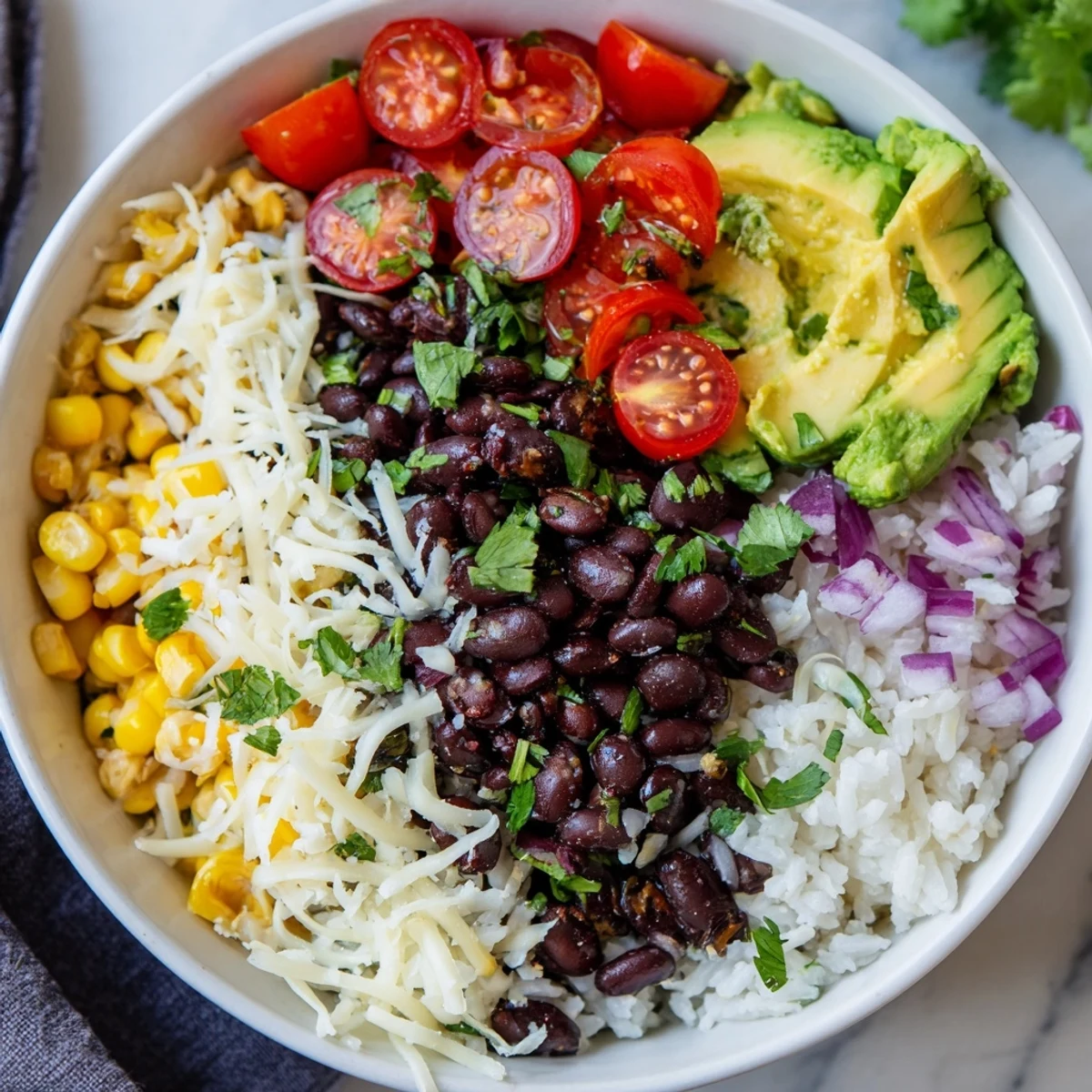 A close-up of a colorful Rice, Bean, and Corn Burrito Bowl, filled with fresh vegetables and creamy toppings.