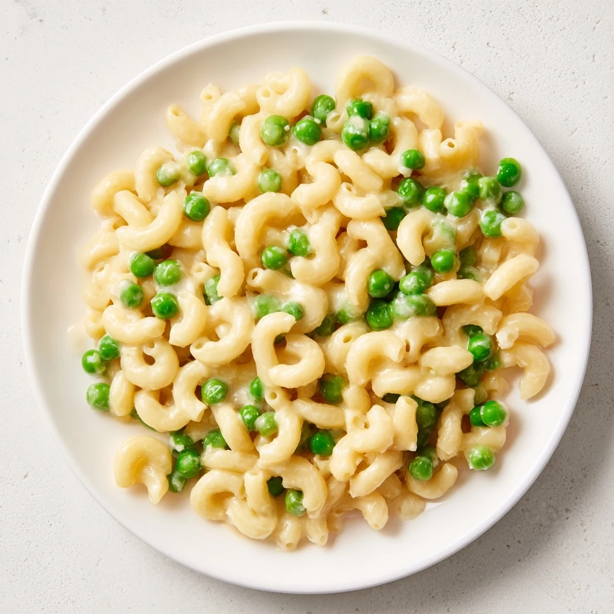Close-up of golden Parmesan sprinkled on a plate of fresh, inviting Macaroni & Peas.