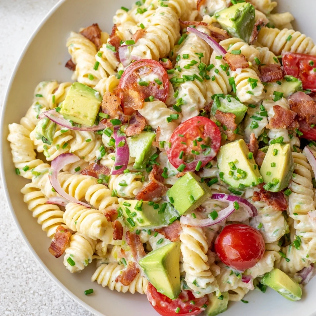 A beautifully presented BLT Pasta Salad, showing off crispy bacon and juicy tomatoes with pasta.