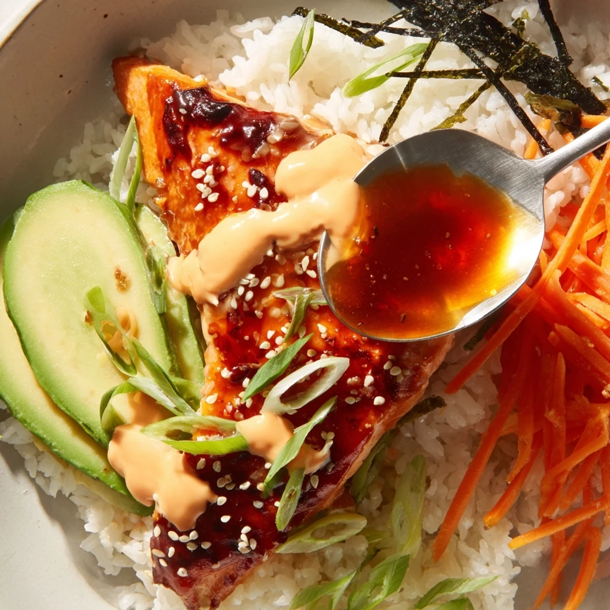 This teriyaki salmon rice bowl features tender salmon in a rich glaze with colorful toppings.