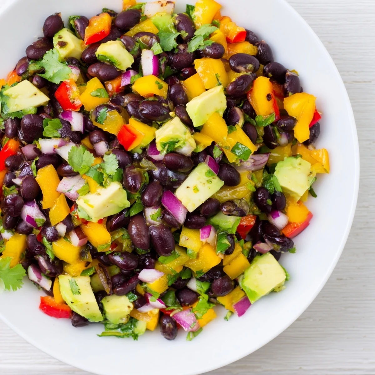 A bright overhead shot displays the flavorful Southwest Black Bean Salad bursting with fresh ingredients.