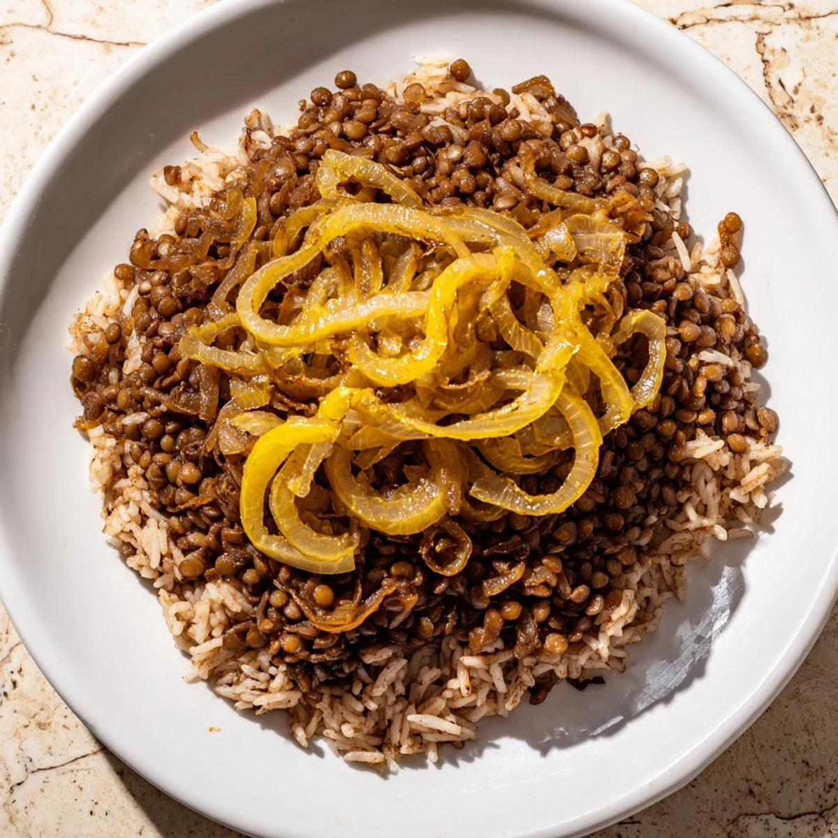 Steaming Lebanese Mjadra, a hearty mix of lentils and rice, is topped with sweet caramelized onions.