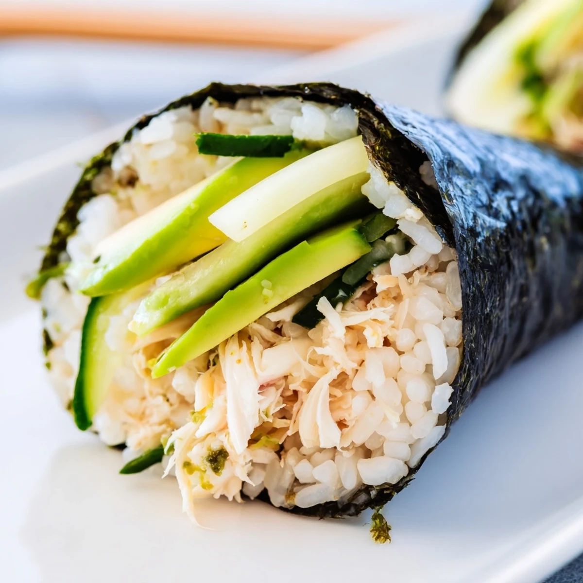 Cone-shaped Sushi Rice Hand Rolls stuffed with crab, avocado, and cucumber, served with pickled ginger.