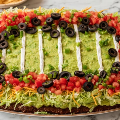 A delicious Football Field Dip Platter with layers of flavorful toppings, perfect for game day.