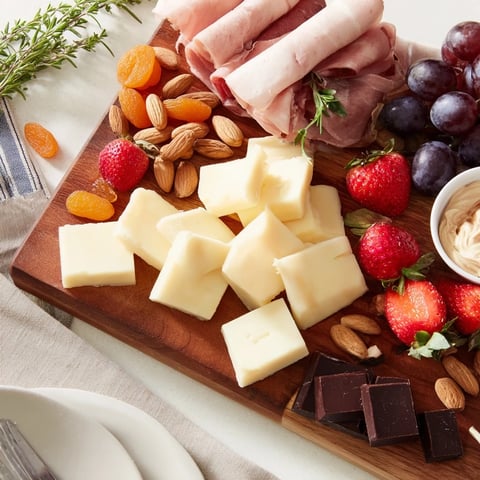 Anniversary Heirloom Arrangement with creamy brie, rich cheddar, and fresh grapes, ready to serve.