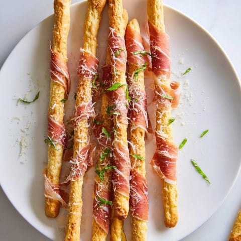 Golden Gate appetizer with prosciutto ribbons draped between breadstick towers, ready to serve.
