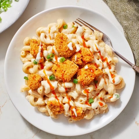 Indulge in creamy white cheddar mac and cheese with crispy chicken goodness.  