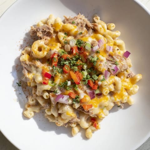 A close-up of a skillet brimming with rich BBQ Rib Macaroni Skillet, garnished with fresh parsley.