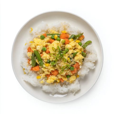 Close-up of golden-brown Frozen Veggie Fried Rice, garnished fresh green onions and sesame seeds.