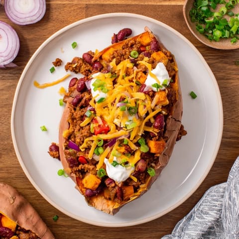 This satisfying baked sweet potato stuffed with chili showcases a rich, savory aroma and visual appeal.