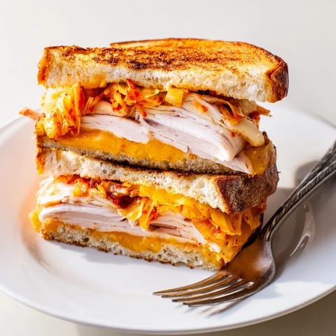 Crispy toasted sourdough surrounds a flavorful Kimchi Turkey & Cheddar grilled cheese, bursting with textures.