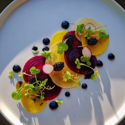An artfully arranged plate of “The Shadow Play” with dark blackberries and olives creating stunning silhouettes.