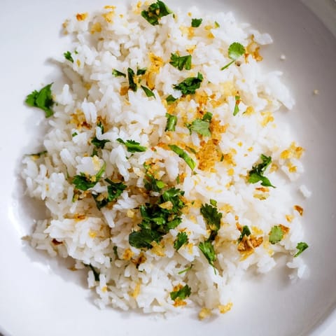 Steamed jasmine rice infused with aromatic garlic oil and garnished with scallions, perfect beside a colorful stir-fry.