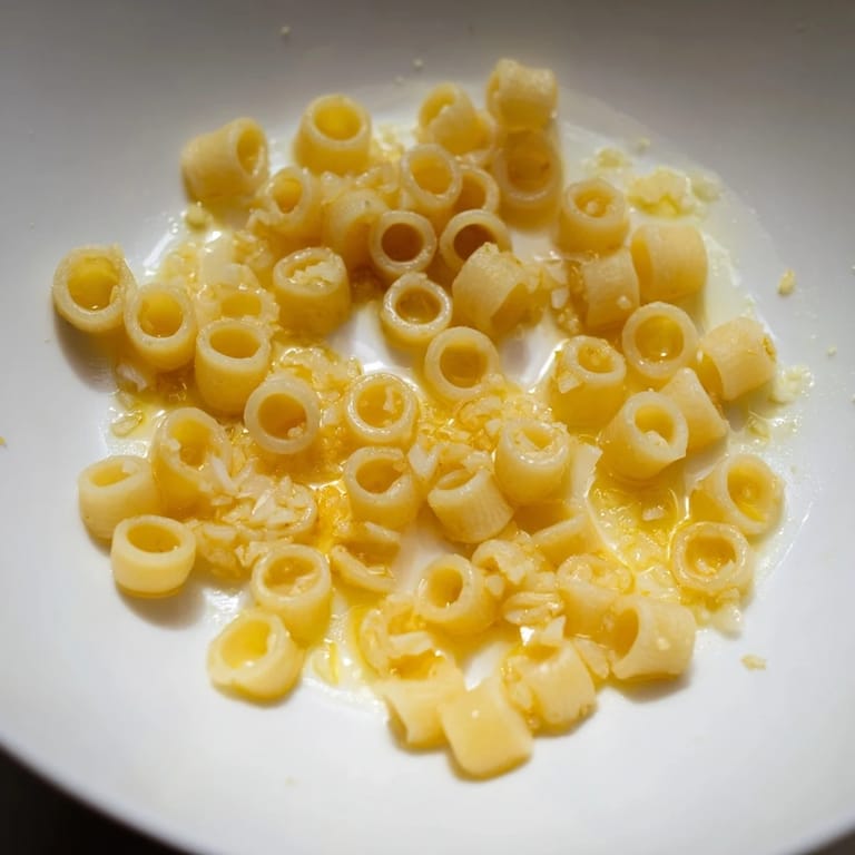 Creamy 3-Ingredient Butter & Garlic Ditalini with glistening garlic, ready to toss for a delicious taste.